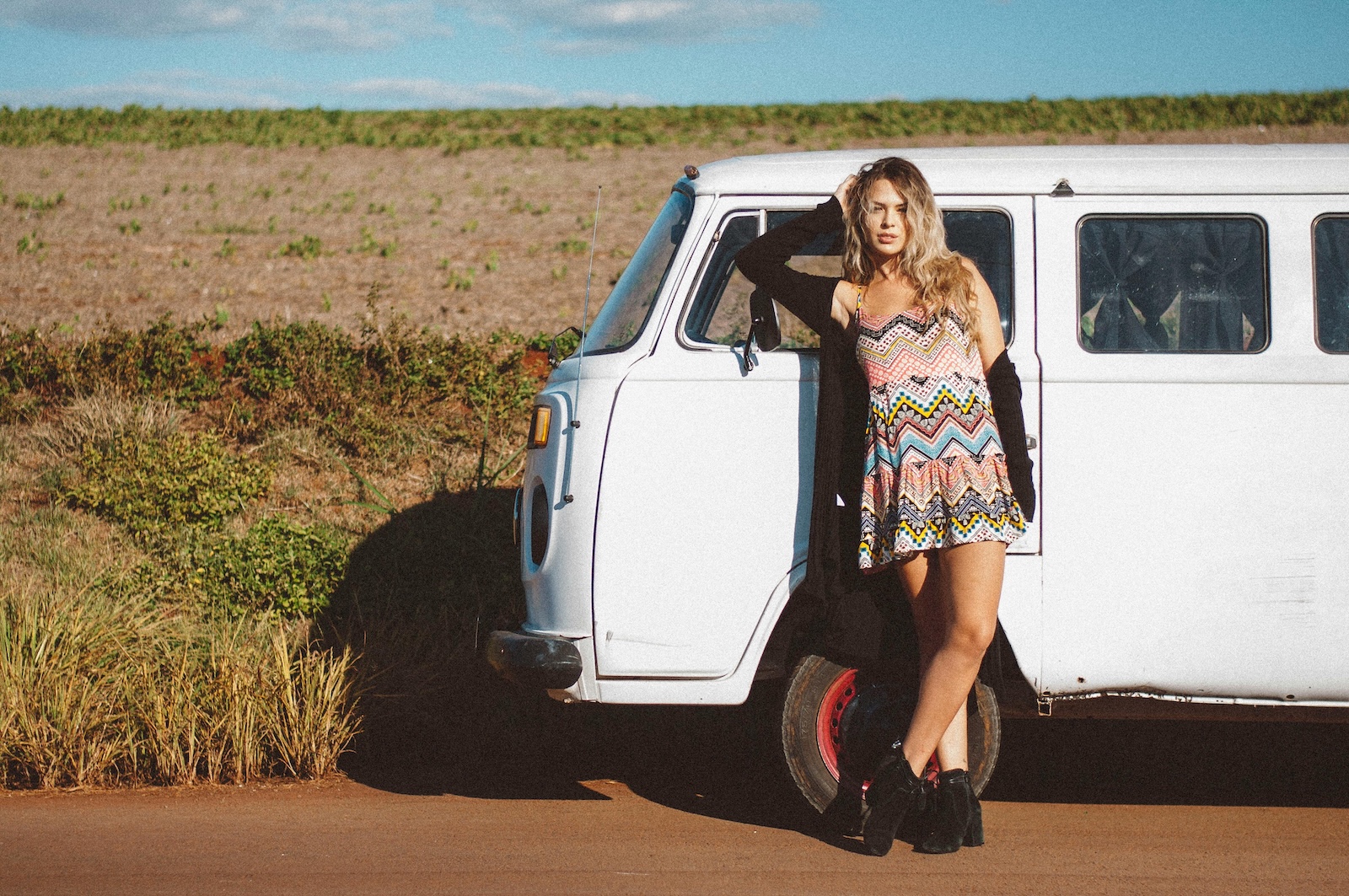 Woman outside on the road standing next to a wagon van